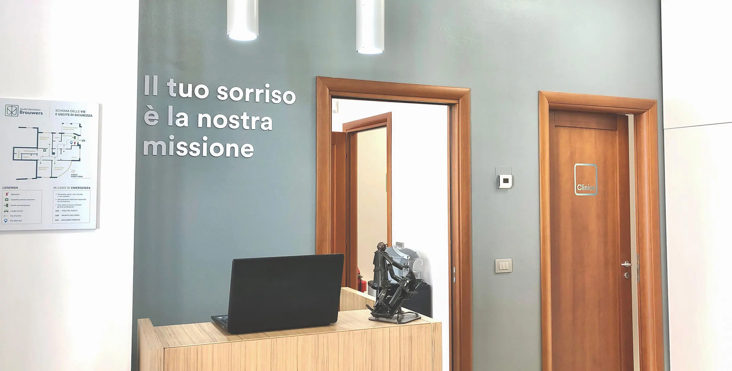 Lo studio di Marghera: la parete col motto, l'accoglienza in legno chiaro e le porte in legno